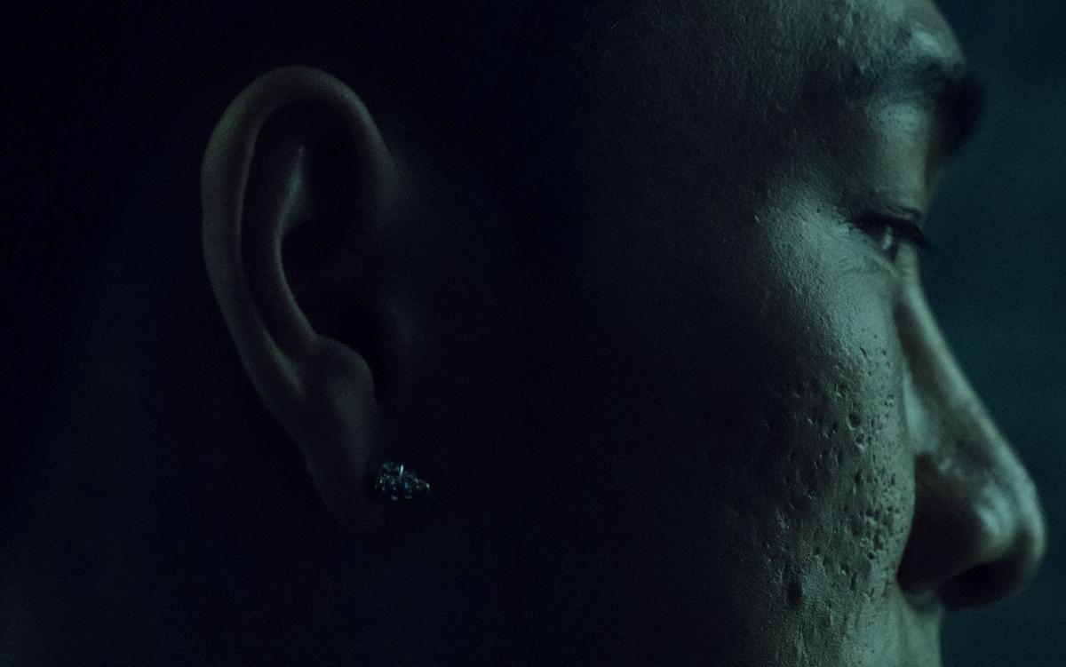Close-up of a person’s face and ear in low light.